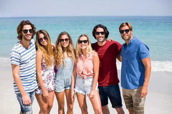 Vänner i solglasögon på stranden på solig dag — Stockfoto