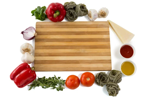 Tabla de cortar en medio de varias verduras — Foto de Stock