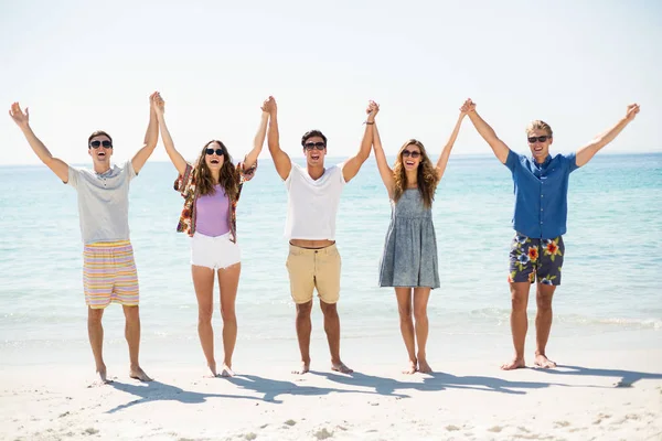 Ευτυχείς φίλοι με τα χέρια υψωμένα στην παραλία — Φωτογραφία Αρχείου