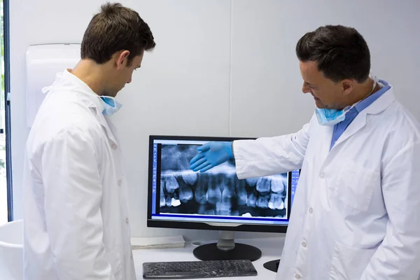 Tandläkaren undersöker röntgen rapport på dator — Stockfoto