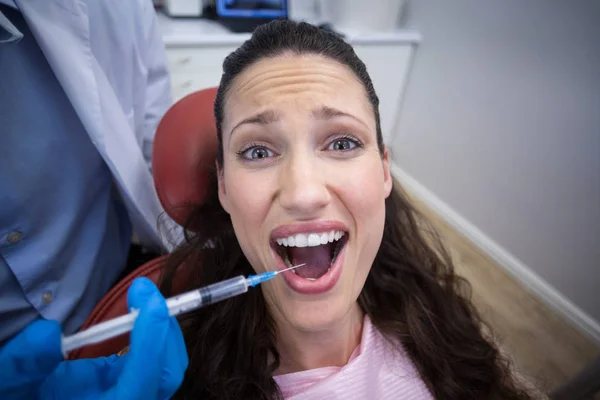 歯医者怖い患者口の中に麻酔薬を注入します。 — ストック写真