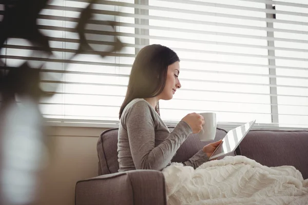 Vrouw met behulp van de tablet terwijl het drinken van koffie — Stockfoto