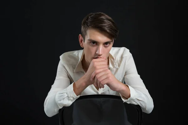 Андрогинный человек, сидящий на стуле — стоковое фото