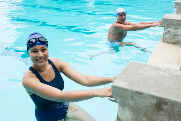 Sorridente anziano uomo e donna a bordo piscina — Foto Stock