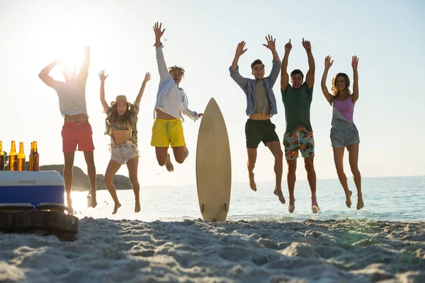 Freunde springen am Strand an Land — Stockfoto