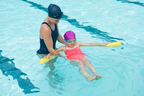 Instructora entrenando a una chica joven en la piscina —  Fotos de Stock