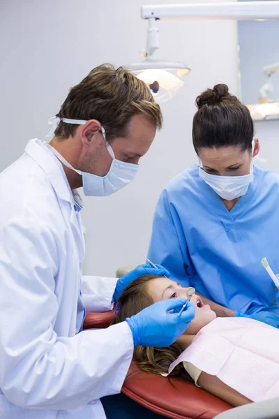 Tandläkaren undersöka en ung patient med verktyg — Stockfoto