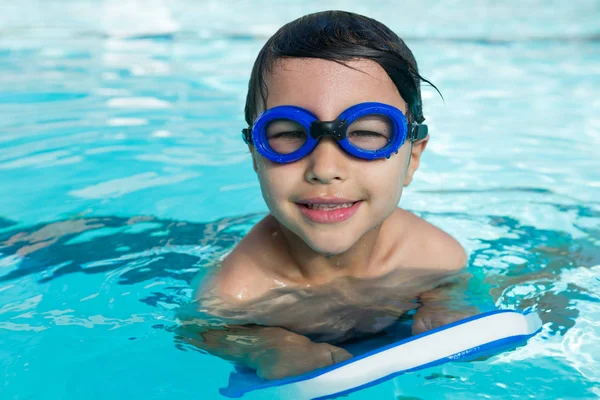 Мальчик в плавательных очках плавает в бассейне — стоковое фото