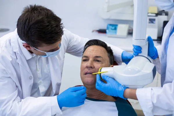 歯科用具を持つ男性患者を調べる — ストック写真