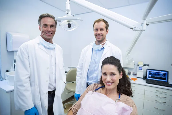 Dentistas sorridentes e paciente do sexo feminino — Fotografia de Stock