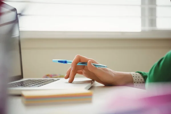 Vrouw werkend op laptop aan tafel — Stockfoto