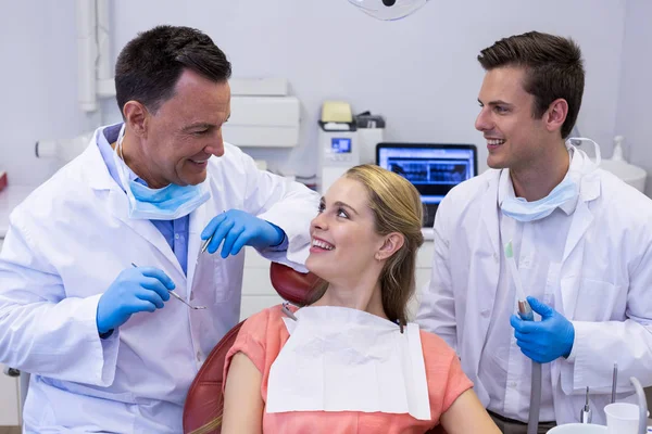 Tandläkare som interagerar med kvinnlig patient — Stockfoto