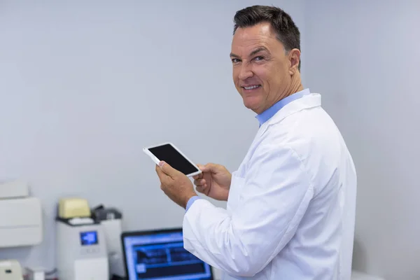 Усміхнений стоматолог тримає цифровий планшет — стокове фото