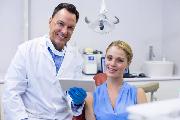Lachende tandartsen en vrouwelijke patiënt — Stockfoto