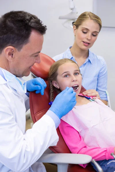 Dentiste examinant avec le jeune patient — Photo