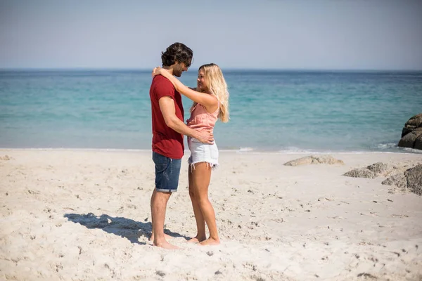 Casal de pé cara a cara na praia — Fotografia de Stock