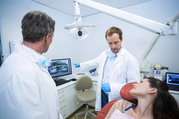 Dentistas mostrando una radiografía de dientes al paciente —  Fotos de Stock