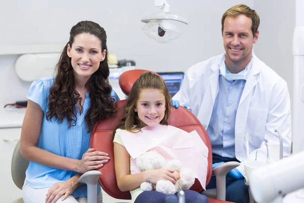 Стоматолог с молодым пациентом и ее матерью — стоковое фото