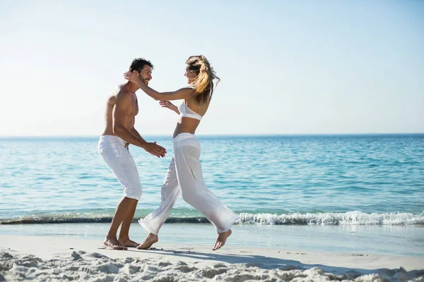 Vista lateral de pareja juguetona en la playa —  Fotos de Stock