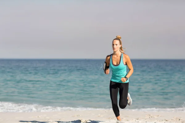 Kvinna som jogging på stranden vid stranden — Stockfoto