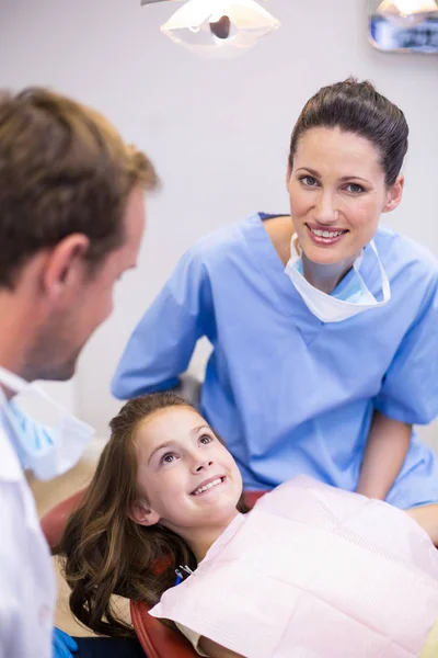 Улыбающиеся дантисты взаимодействуют с молодым пациентом — стоковое фото