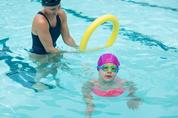 Instructora entrenando a una chica joven en la piscina — Foto de Stock