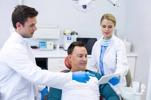 Dentists showing dental report on tablet — Stock Photo, Image