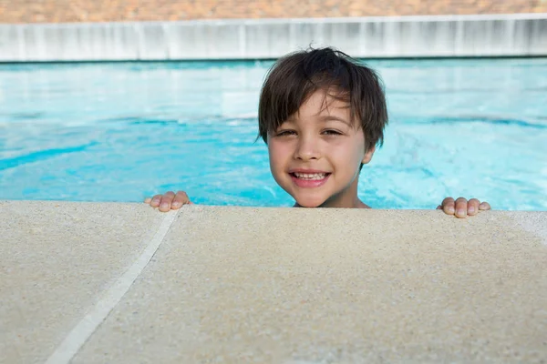 Маленький мальчик улыбается в бассейне — стоковое фото