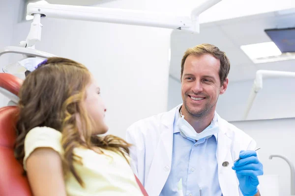 Smiling dentist talking to young patient — Stock Photo, Image