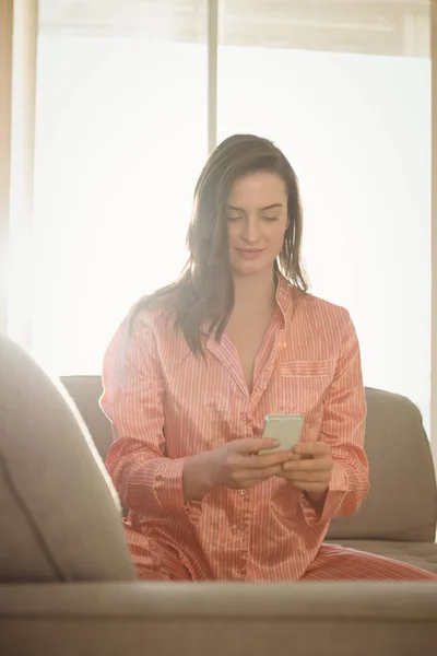 Woman in night dress using smartphone — Stock Photo, Image