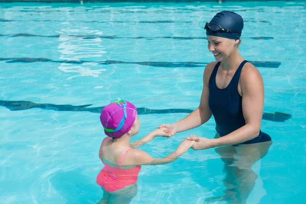 Instructora entrenando a una chica joven en la piscina — Foto de Stock