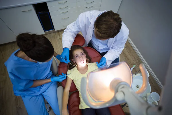 Dentistas examinando um paciente jovem com ferramentas — Fotografia de Stock