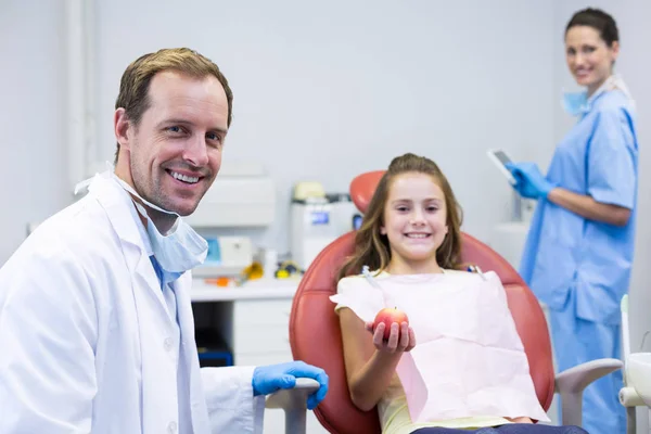 Dentisti sorridenti e giovane paziente — Foto Stock