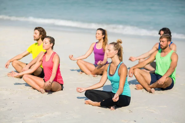 Vrienden mediteren op strand — Stockfoto