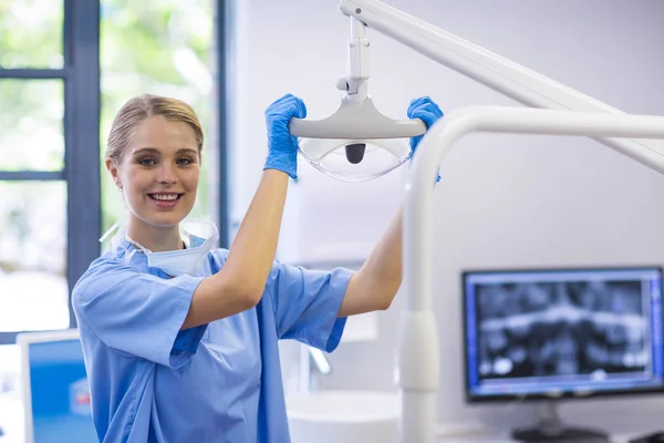 歯の光を調整する女性看護師 — ストック写真