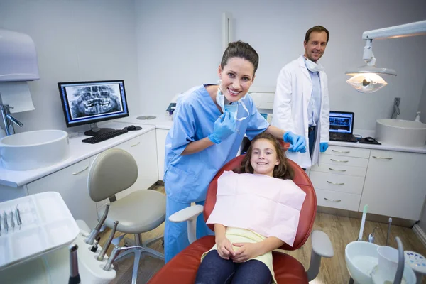 Dentisti sorridenti e giovane paziente — Foto Stock