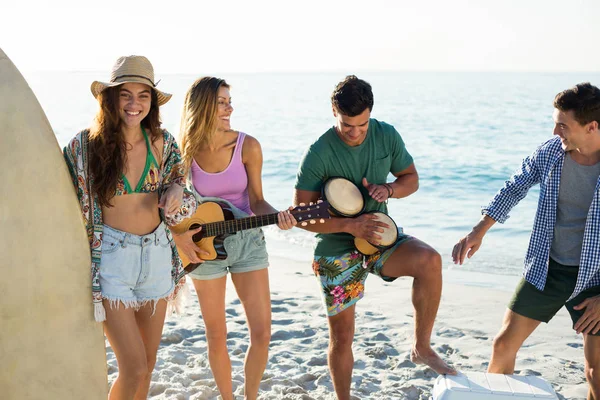 Vänner njuter musik när du står på stranden — Stockfoto