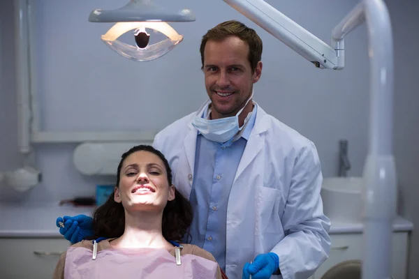 Dentistas sonrientes y paciente joven —  Fotos de Stock