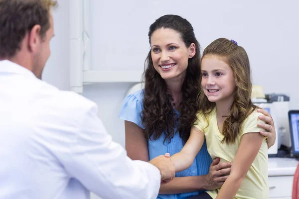 Dentist shaking hand with daughter — Stock Photo, Image