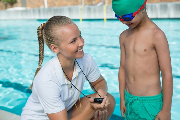 Female trainer showing stopwatch to boy — Stock Photo, Image