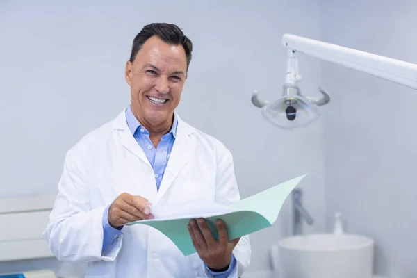 Portrait of smiling dentist holding file — Stock Photo, Image