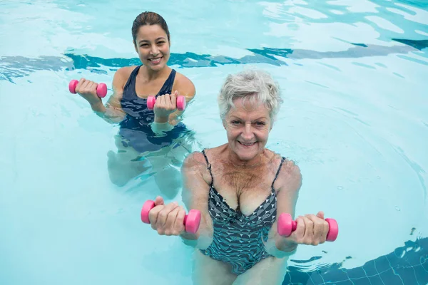 Treinador e mulher sênior exercitando com halteres — Fotografia de Stock