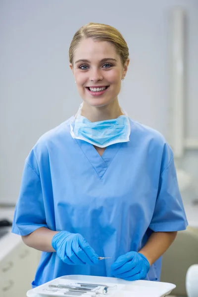 Happy female nurse holding dental tool — Stock Photo, Image