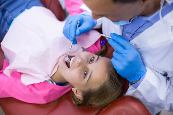 Dentista examinando um paciente jovem com ferramentas — Fotografia de Stock