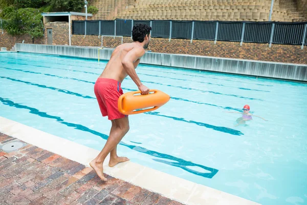 Lifeguard jumping into swimming pool — Stock Photo, Image