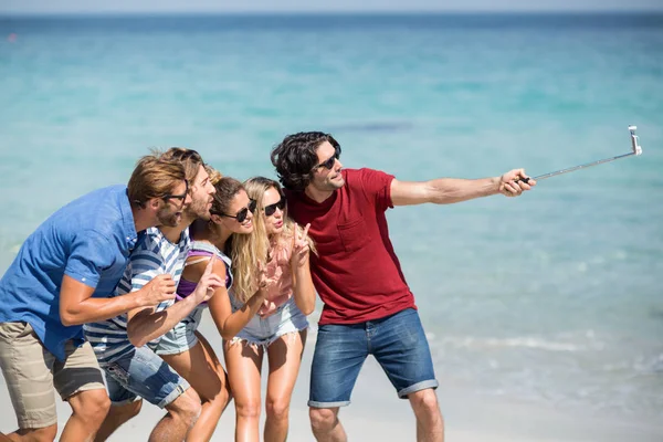 Amigos alegres tomando selfie na praia — Fotografia de Stock