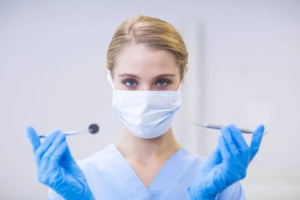 Female nurse holding dental tools — Stock Photo, Image