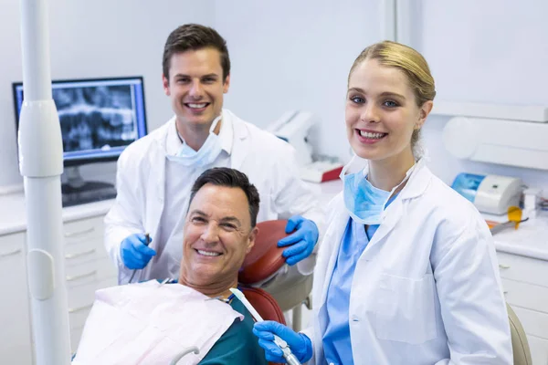 Lachende tandartsen en mannelijke patiënt — Stockfoto