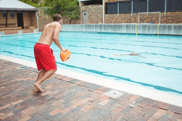 Lifeguard jumping into swimming pool — Stock Photo, Image