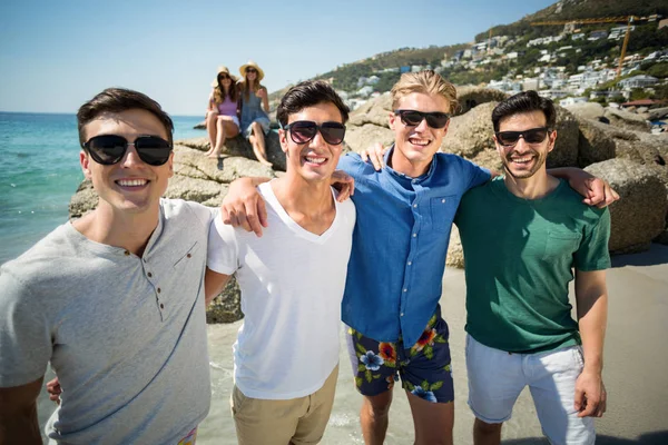 Mannelijke vrienden permanent op strand tijdens zonnige dag — Stockfoto